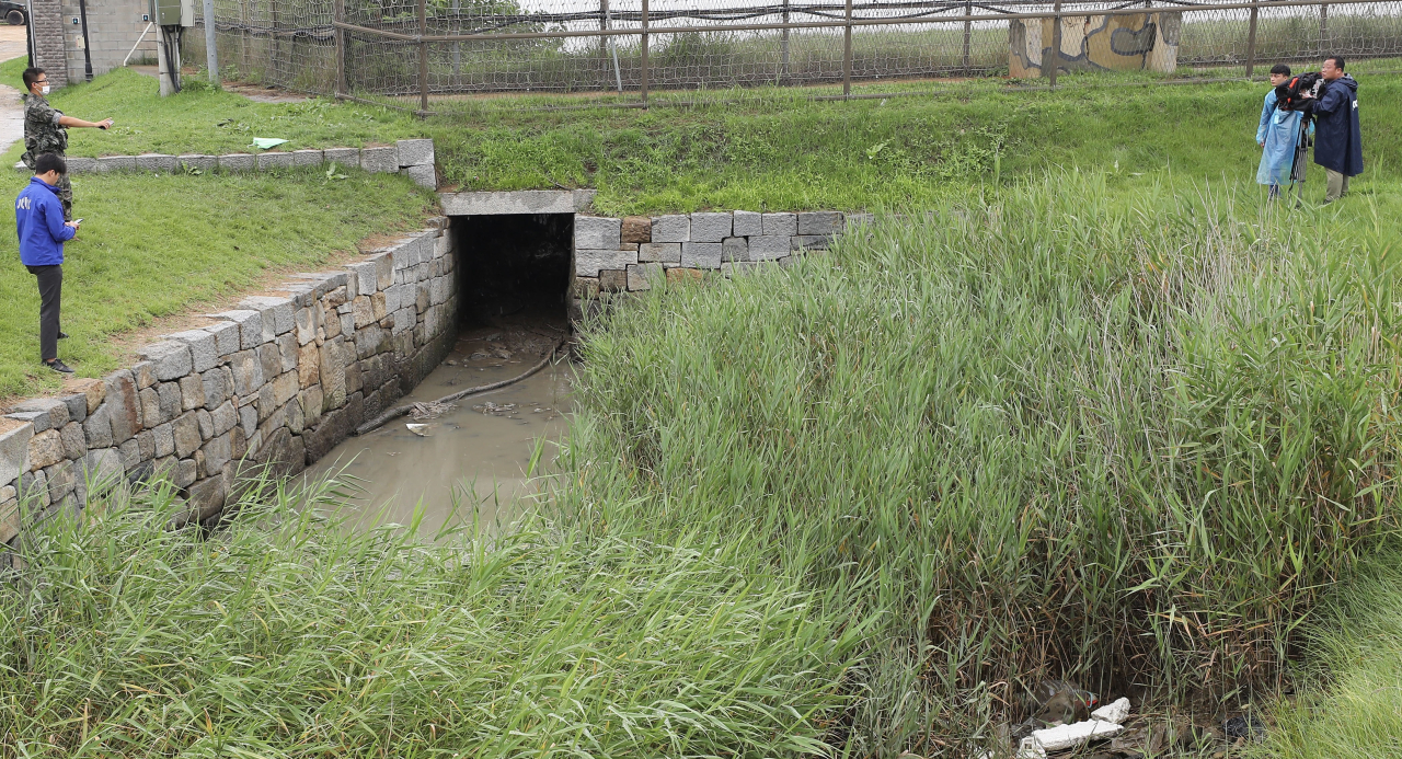 The photo taken on Tuesday shows a drain that runs under barbed wire fences in Ganghwa Island, west of Seoul, which may have been used by a North Korean defector to cross the border and return home. (Yonhap)