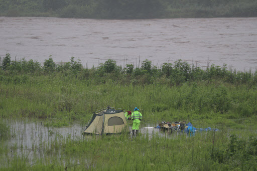 Safety officers move a camper’s tent near Imjin River in Yeoncheon County, Gyeonggi Province, on Wednesday, as the river’s water level rises from days of heavy downpours. (Yonhap)