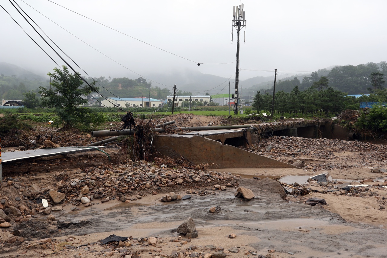 A road in Chungju, North Chungcheong Province, is pulverized Thursday due to heavy rainfall in the region. (Yonhap)