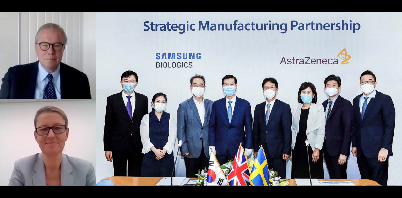 AstraZeneca Korea CEO Kim Sang-pyo (fourth from right), Samsung Biologics CEO Kim Tae-han (fourth from left) and officials from the Health Ministry and Industry Ministry convene to sign a letter of intent on June 25 at Samsung Biologics’ headquarters in Songdo, Incheon. AstraZeneca‘s Chairman Leif Johansson (top screen) and Asia-Pacific product supply head Margareta Ozolins Nordvall (lower screen) joined online due to COVID-19. (Samsung Biologics)