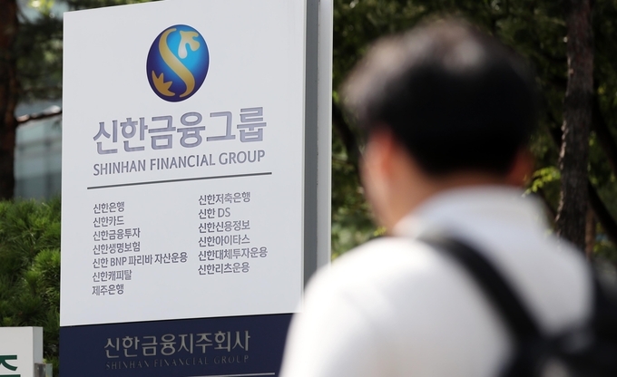 A pedestrian walks past Shinhan Financial Group headquarters in Seoul. (Yonhap)