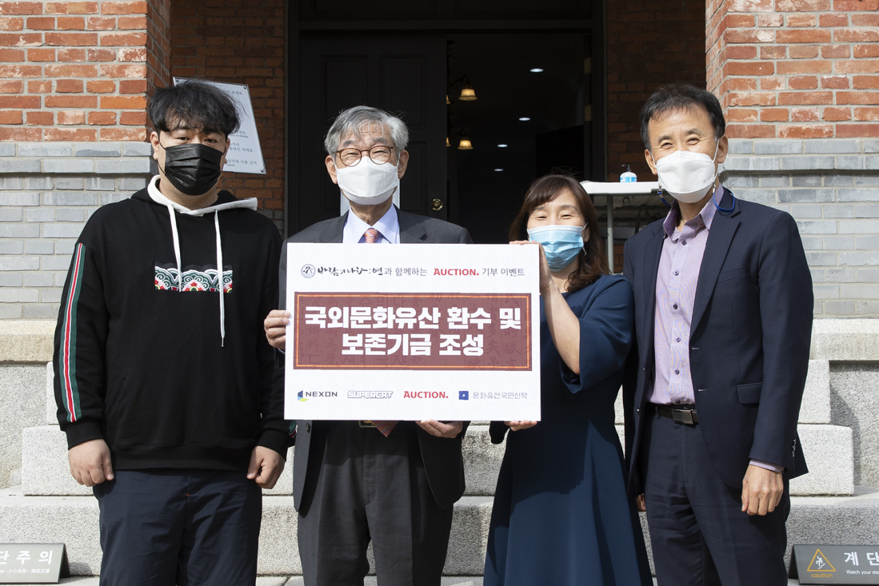 Officials of Supercat, Auction and the National Trust for Cultural Heritage pose for a photo during a donation event held at Deoksu Palace in central Seoul on Wednesday. (Nexon)