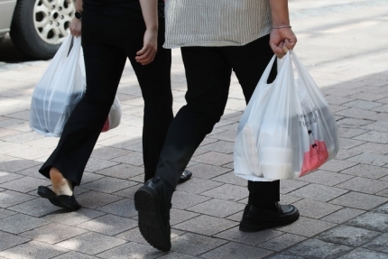 Consumers holding takeout food are seen during a lunch break in downtown Seoul earlier this year. (Yonhap)