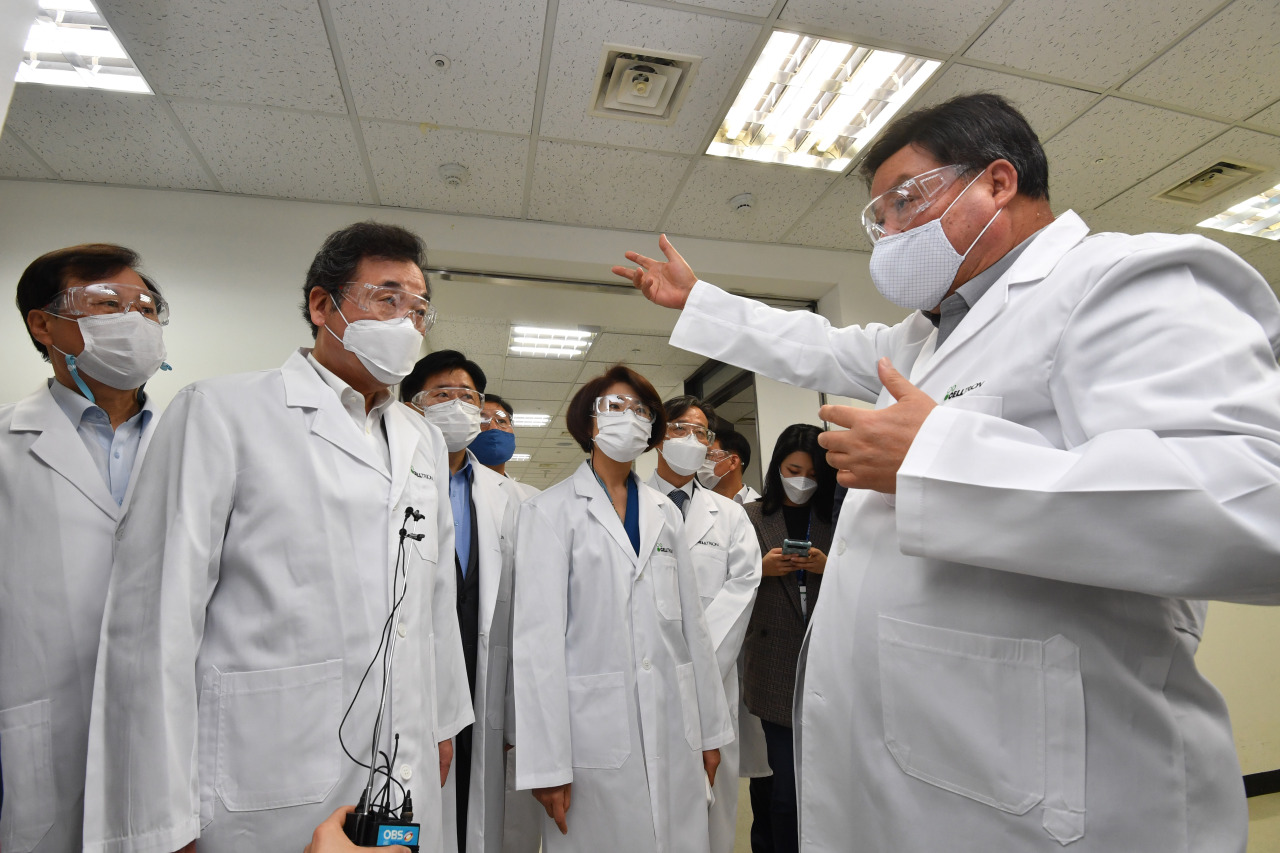 Lee Nak-yon (second from left), chairman of the ruling Democratic Party of Korea, is briefed on the latest developments from drugmaker Celltrion by its chief, Seo Jung-jin (far right), at its Incheon plant, Oct. 18, 2020. (Yonhap)
