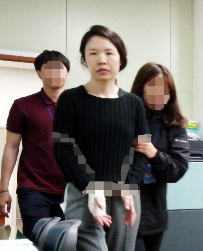 Police escort Koh Yu-jeong to the Jeju Dongbu Police Station on June 7. (Yonhap)