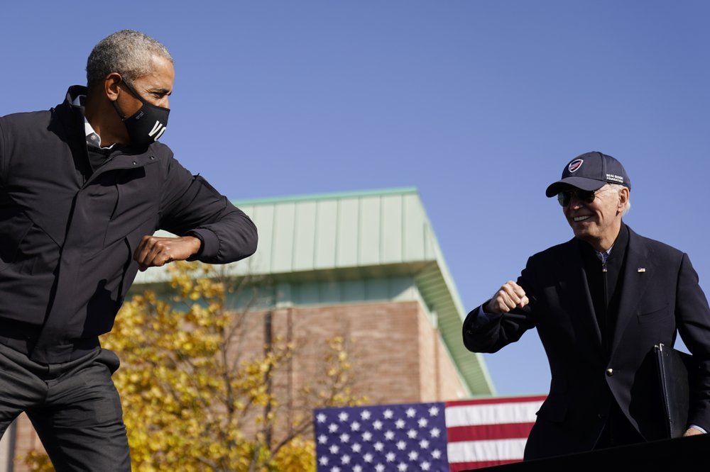 Joe Biden, right, and former President Barack Obama greet each other with an air elbow bump, at the conclusion of rally at Northwestern High School in Flint, Mich on Oct. 31. (AP-Yonhap)