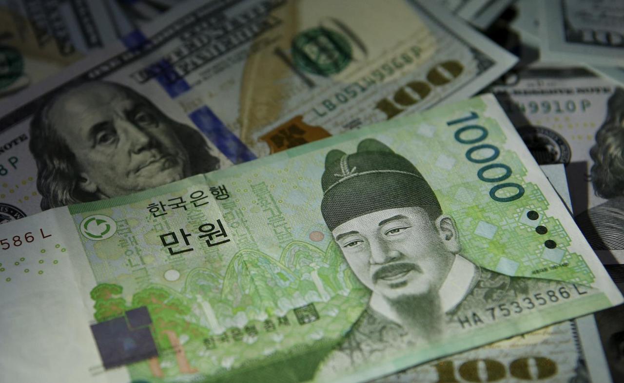 South Korean 10,000 won note is seen on 100 dollar notes in this picture illustration taken in Seoul, South Korea. (Reuters-Yonhap)