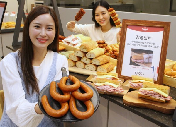 Models pose for a photo with processed meat products at Lotte Department Store in central Seoul on Oct. 12. (Lotte Shopping Co.)