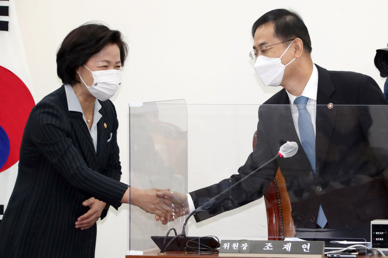 Justice Minister Choo Mi-ae shakes hands with Cho Jae-youn, head of the National Court Administration, during a meeting held to choose two finalists who will head the Corruption Investigation Office for High-ranking Officials at the National Assembly in Seoul, Friday.  (Yonhap)