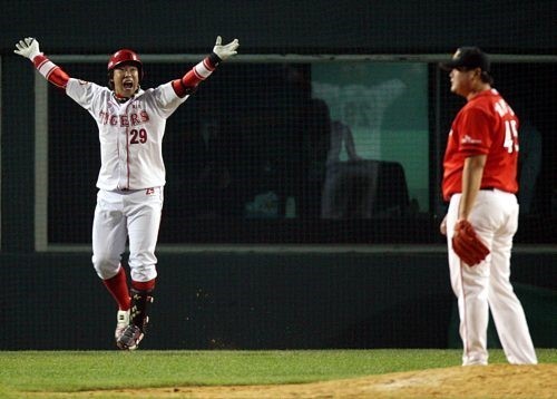Na Ji-wan of the Kia Tigers (L) celebrates after launching a walk-off home run off Chei Byung-yong of the SK Wyverns (R) in the bottom of the ninth inning of Game 7 of the Korean Series at Jamsil Baseball Stadium in Seoul on Oct. 24, 2009. (Yonhap)
