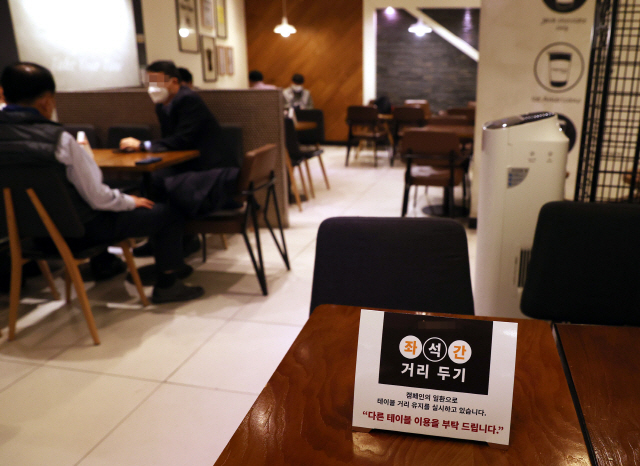 A sign on a table asks customers to use a different table to ensure social distancing at a cafe in Seoul on Wednesday. (Yonhap)