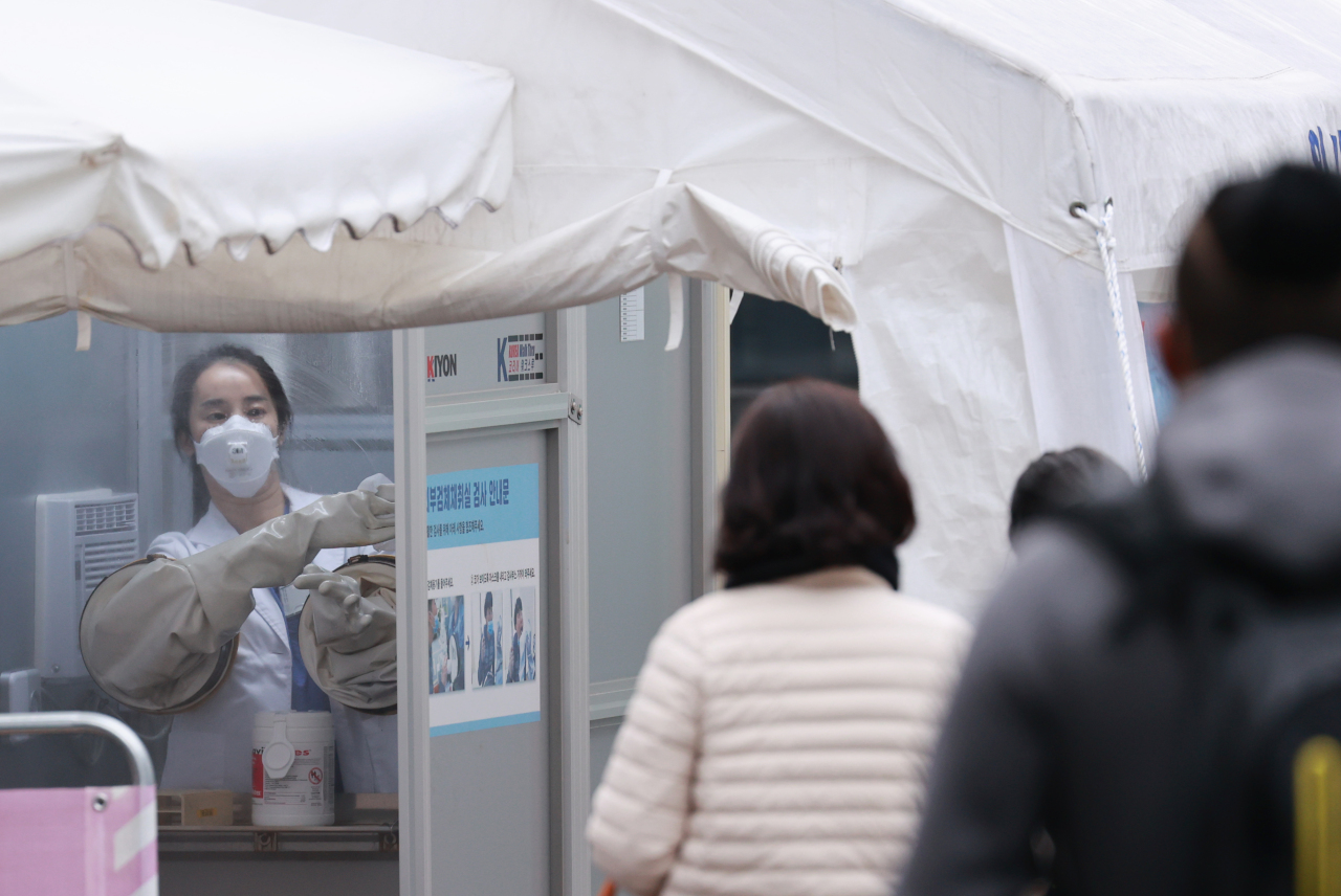 A health worker disinfects a testing site in central Seoul after conducting coronavirus tests on Friday. (Yonhap)