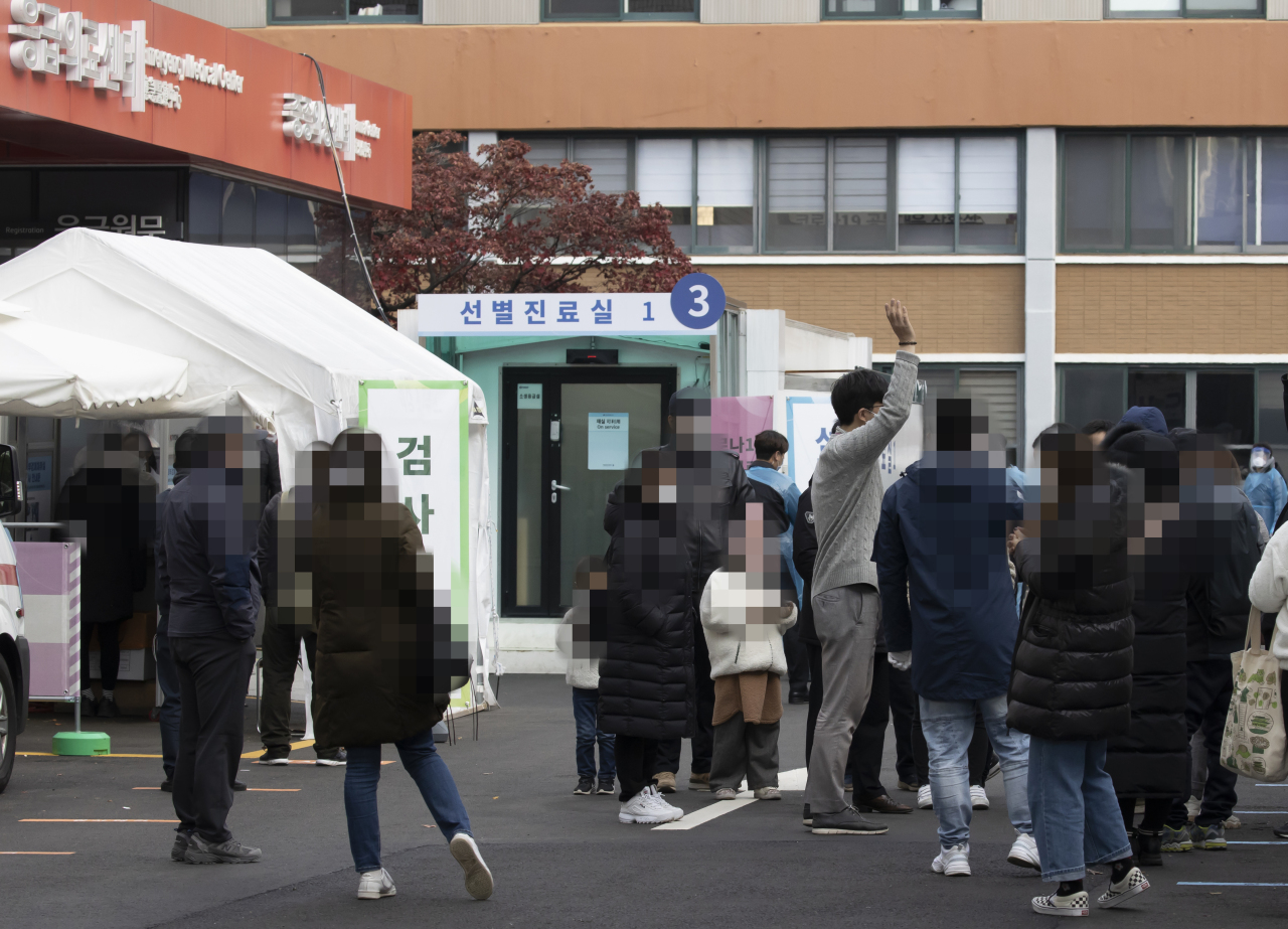 People are in line to take a COVID-19 test. (Yonhap)