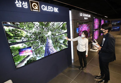 People looking at Samsung Electronics Co.'s QLED 8K TV at an electronics shop in Seoul. (Yonhap)