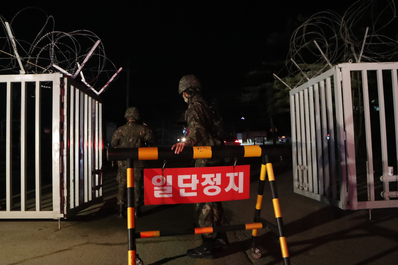 Soldiers close the front gate of an Army boot camp in the northern county of Yeoncheon on Wednesday, after 60 newly enlisted soldiers tested positive for the new coronavirus. (Yonhap)