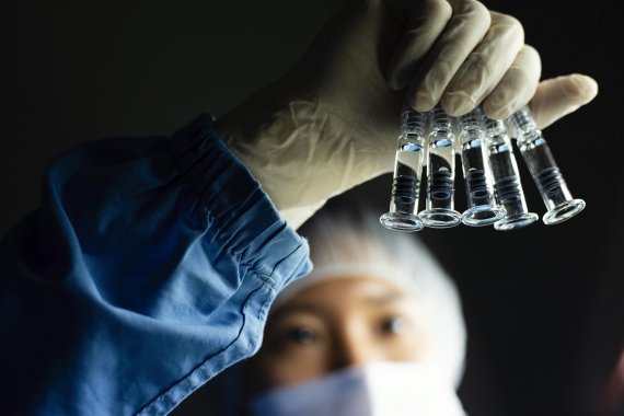 An SK Bioscience researcher inspects vaccine vials. (SK Bioscience)