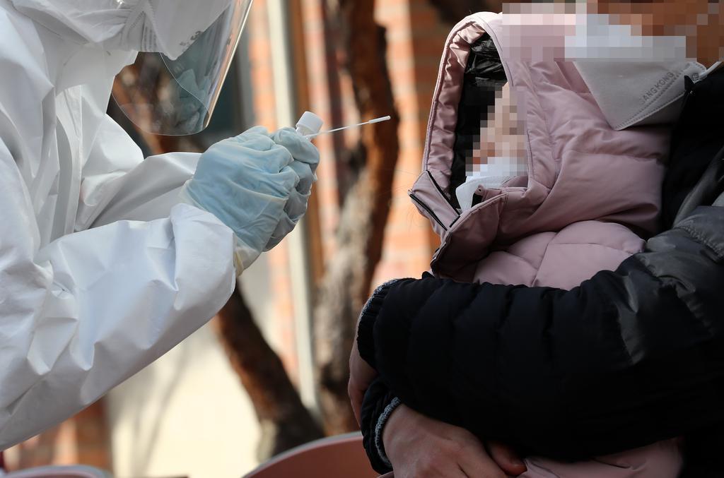 A medical worker conducts a coronavirus test on a child at an elementary school in the central city of Daejeon on Saturday. (Yonhap)