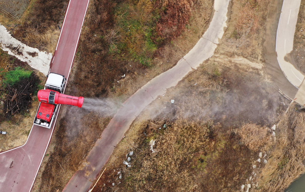 A truck sprays disinfectant at a wild bird habitat in Icheon, south of Seoul, on Nov. 20. (Yonhap)