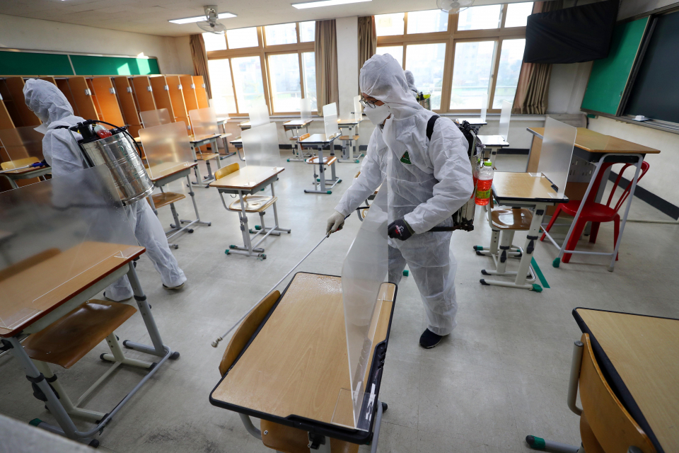 Health workers disinfect a school in the southeastern city of Daegu on Nov. 26, amid a resurgence of the coronavirus ahead of the national college entrance exam slated for Thursday. (Yonhap)