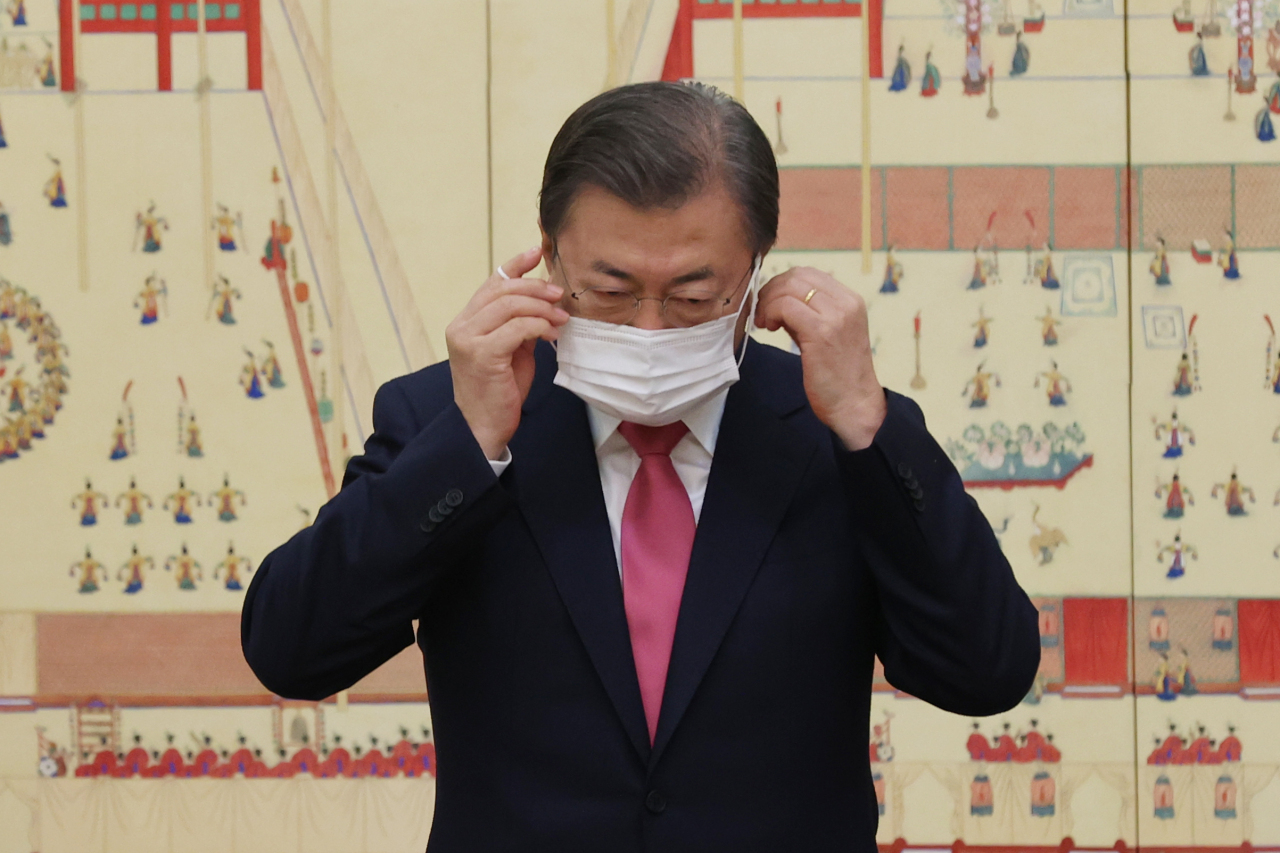 President Moon Jae-in takes off his mask for a commemorative photo with a group of newly appointed ambassadors during a ceremony at Cheong Wa Dae on Wednesday. (Yonhap)
