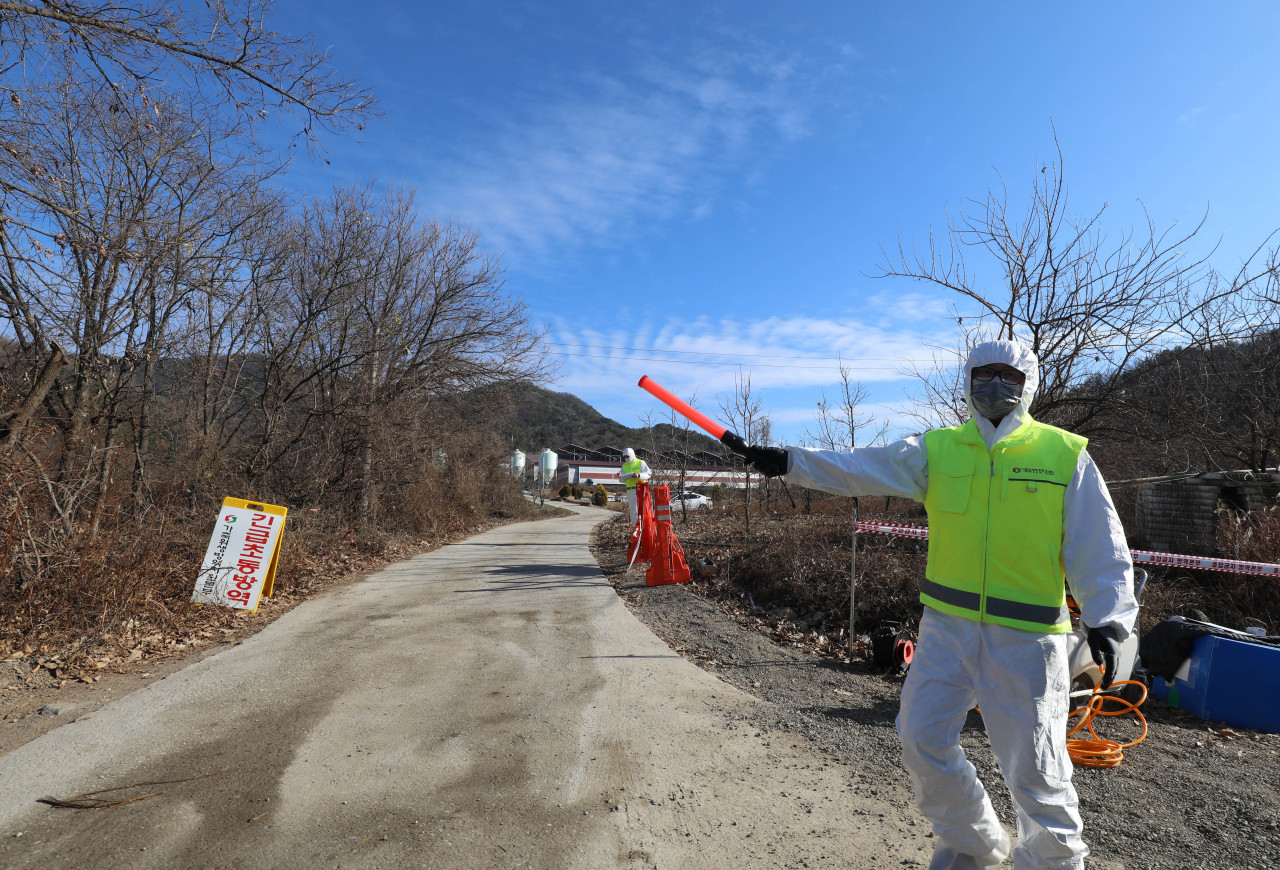 A quarantine official bans the entry of automobiles into a farm in Sangju, 270 km southeast of Seoul, after it reported a highly pathogenic avian influenza case from chickens. (Yonhap)