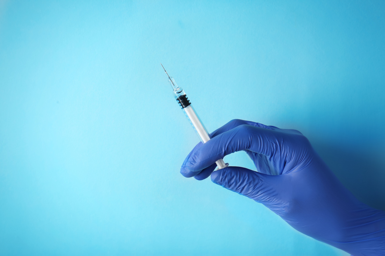 Stock photo of a hand holding up a vaccine shot (123rf)