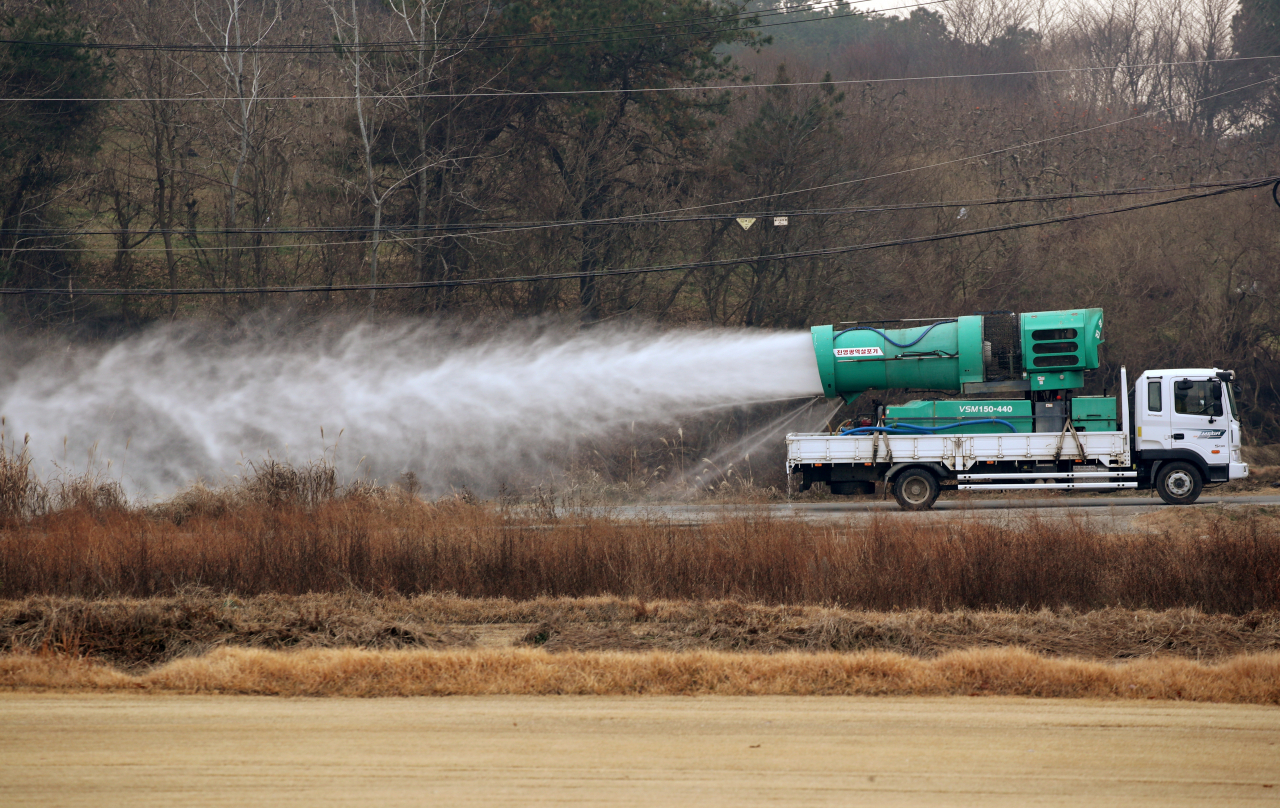 A truck sprays disinfectant near a duck farm in Janseong in South Jeolla Province last Friday, after outbreak of a highly pathogenic bird flu in the region. (Yonhap)