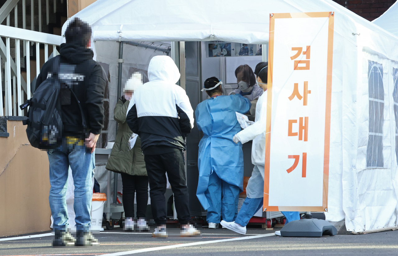 Citizens line up for tests at a COVID-19 test center in Seoul on Wednesday. (Yonhap)