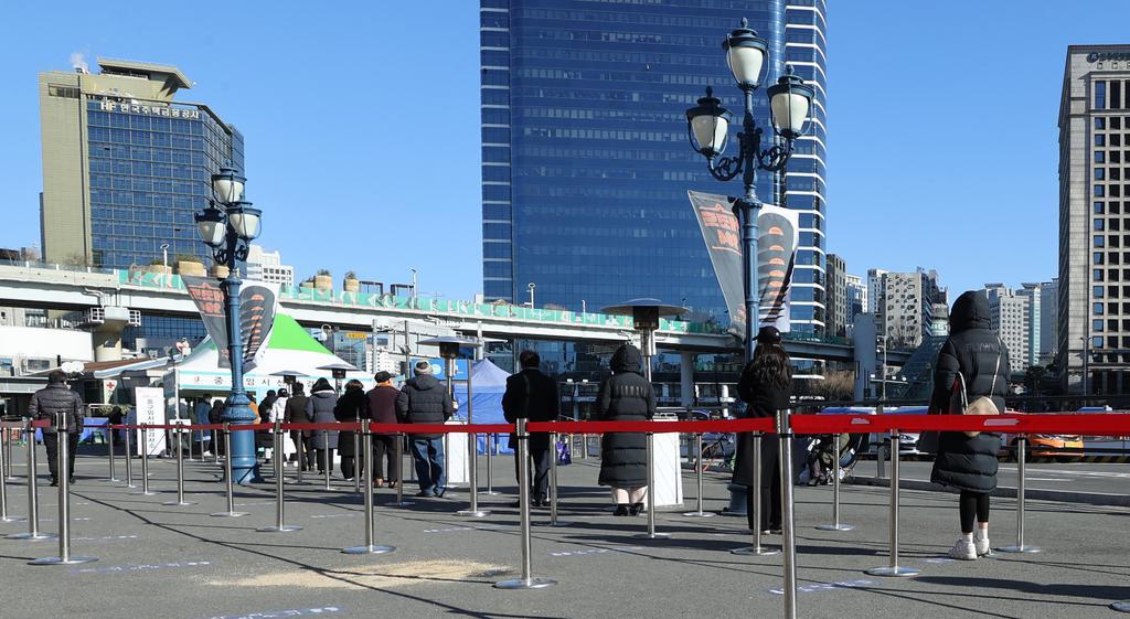 People stand in line to take coronavirus tests at a temporary screening center in front of Seoul Station in central Seoul on Wednesday. (Yonhap)