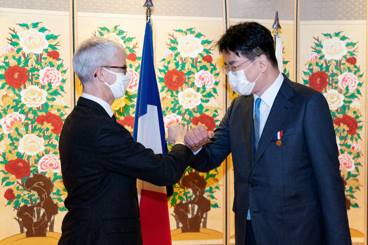 Korean Air CEO Cho Won-tae (right) shakes hands with Franck Rieste, Minister-delegate for Foreign Trade and Economic Attractiveness of France, at a diplomatic event in Seoul on Thursday. (Korean Air)