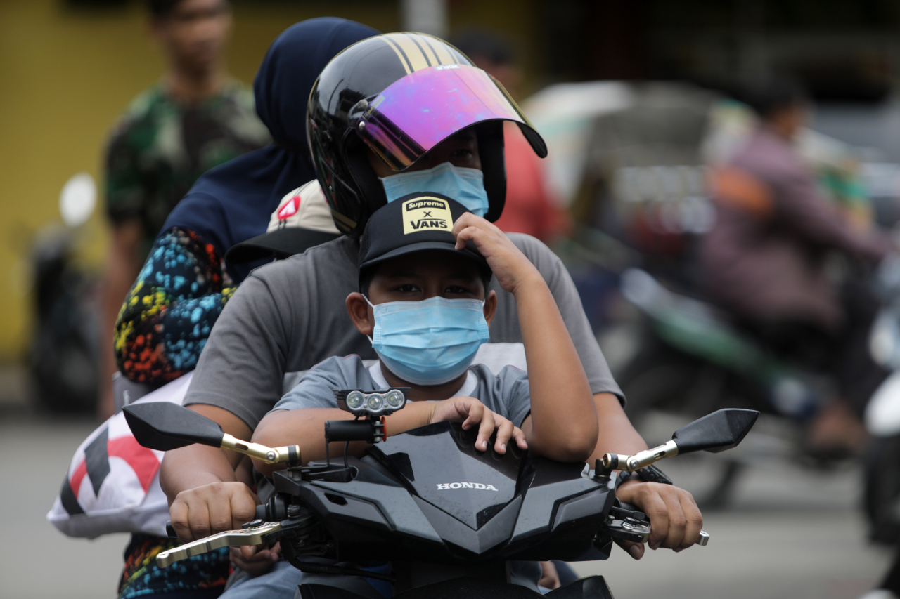 People wearing masks travel on a motorcycle in Banda Aceh, Indonesia, on Thursday. (EPA-Yonhap)