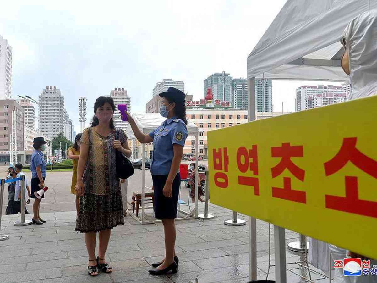 This photo, released by the North's Korean Central News Agency on Aug. 29, 2020, shows an official taking a citizen's temperature at Pyongyang Station in the capital to prevent an outbreak of the coronavirus. (KCNA-Yonhap)