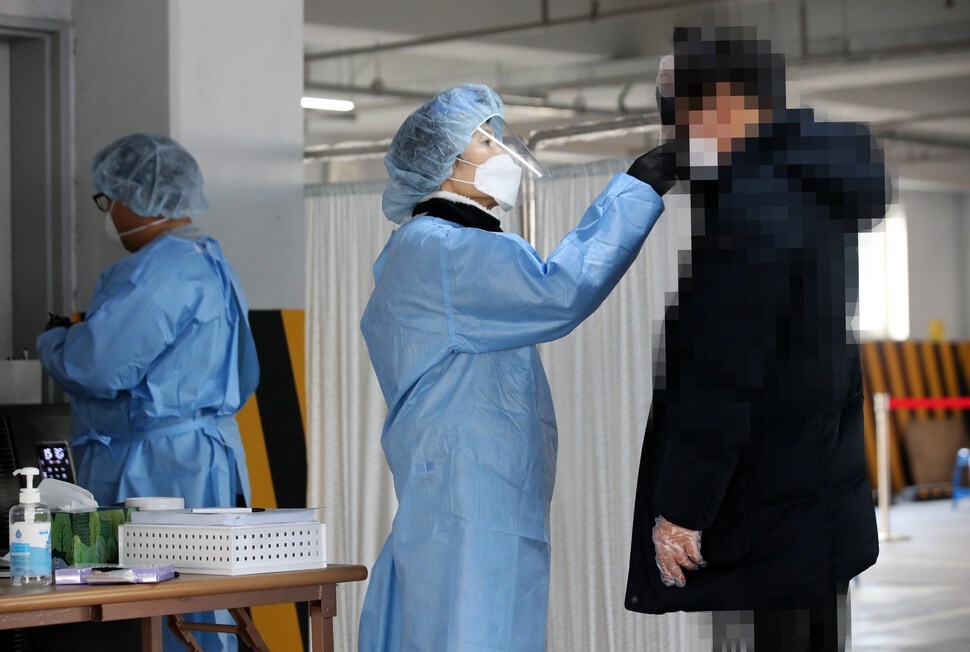 A medical worker checks the temperature of a visitor before a COVID-19 test at a testing center in Gwangju on Tuesday. (Yonhap)