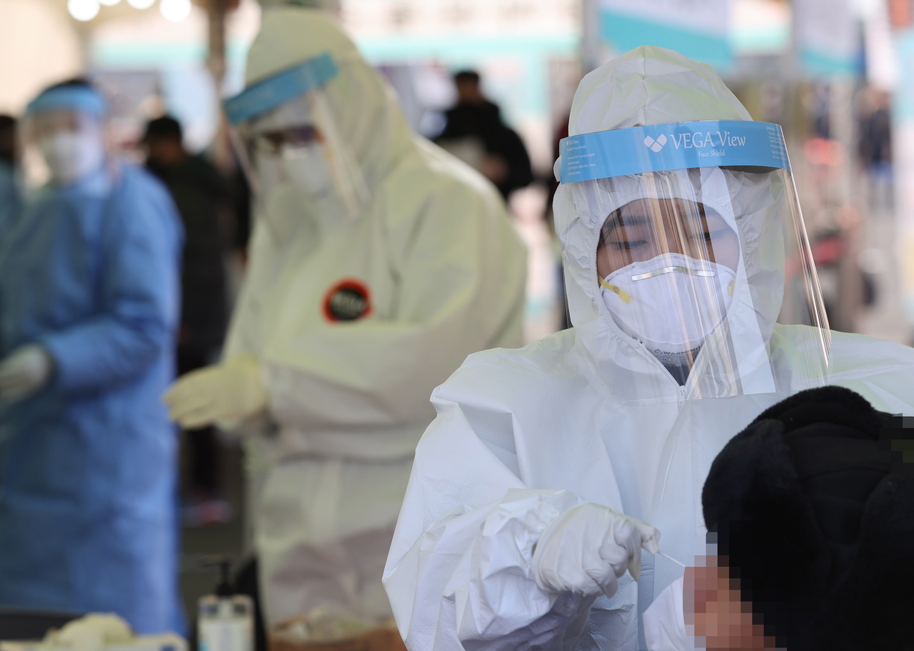 Medical workers conduct COVID-19 testing at a temporary screening center outside Seoul Station in central Seoul on Saturday. (Yonhap)