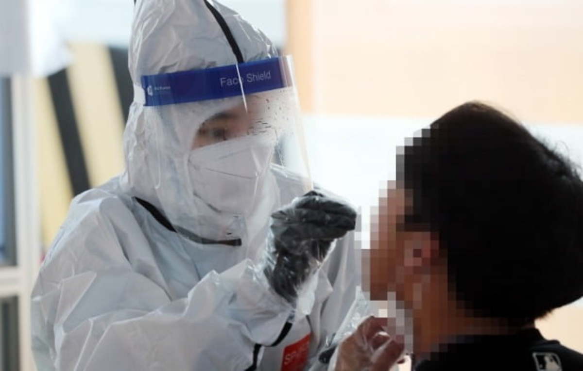 A medical worker administers a COVID-19 test at a testing center in Seoul last Thursday. (Yonhap)