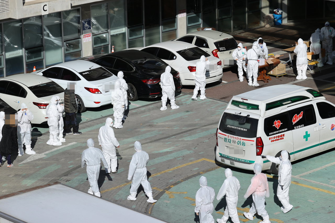 Hospital workers are lined up at an elderly medical facility in Guro-gu, southwestern Seoul, on Wednesday to receive COVID-19 checks. A number of elderly care facilities have reported mass cluster infections and threaten Korea's response to the virus outbreak over this month. (Yonhap)