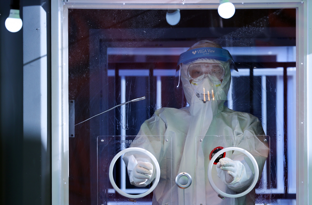 This photo taken on Saturday, shows a medical worker at a temporary COVID-19 testing center in Seoul Station. (Yonhap)