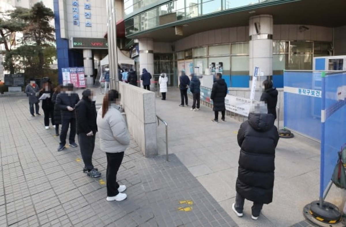 People stand in line to undergo COVID-19 testing at a temporary screening station in western Seoul on Tuesday. (Yonhap)