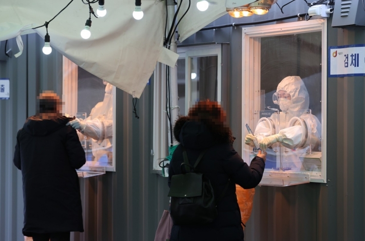Medical workers collect specimens for coronavirus testing at a makeshift clinic in front of Seoul Station on Monday. (Yonhap)