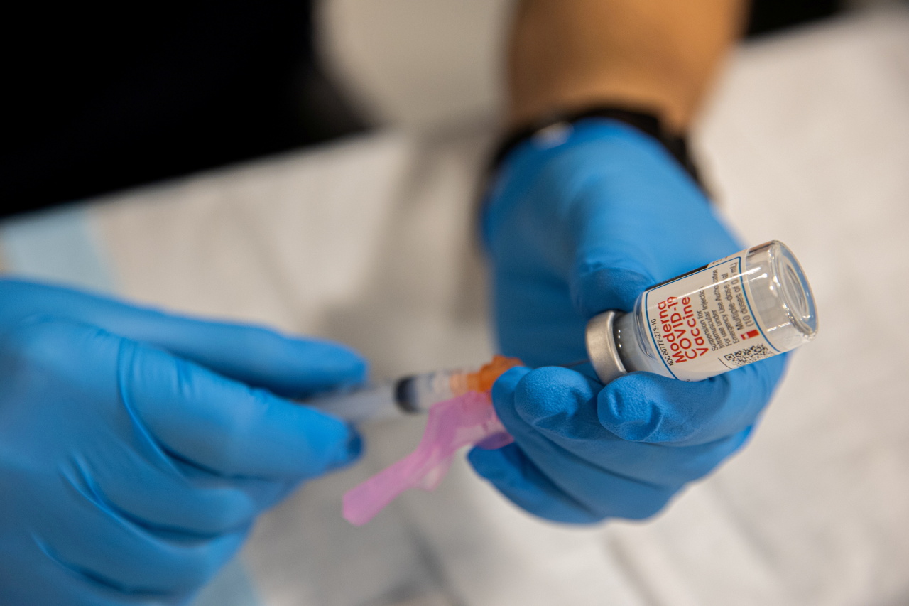 A health care worker prepares a dose of the Moderna COVID-19 vaccine at Queens Police Academy in the Queens borough of New York, Monday. (Reuters-Yonhap)