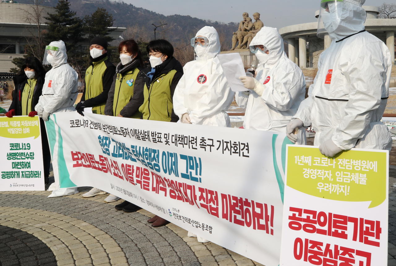 Members of the Korean Health and Medical Workers' Union hold a news conference in front of Cheong Wa Dae in Seoul on Tuesday, to call on the government to increase compensation for medical workers at COVID-19-fighting public hospitals. (Yonhap)
