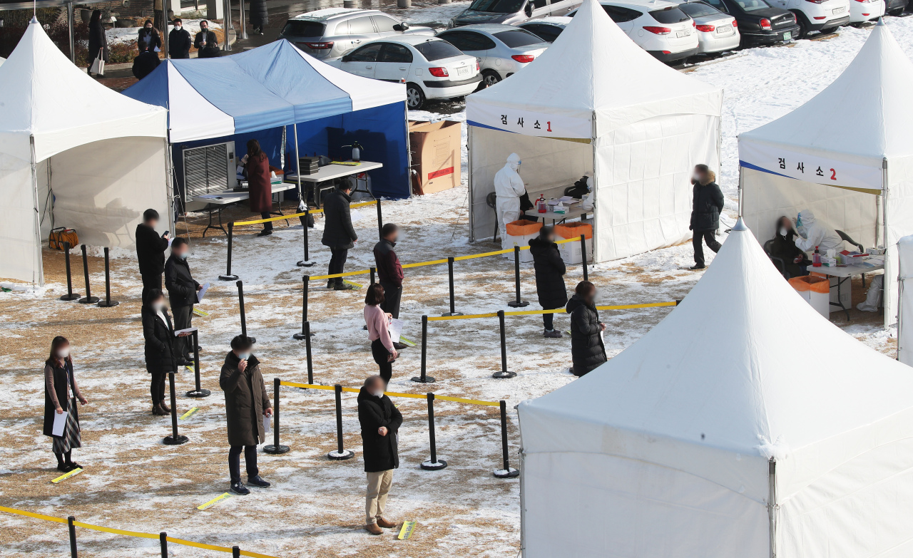 Visitors wait in line to receive COVID-19 tests at a makeshift clinic in Suwon, south of Seoul, on Wednesday. (Yonhap)