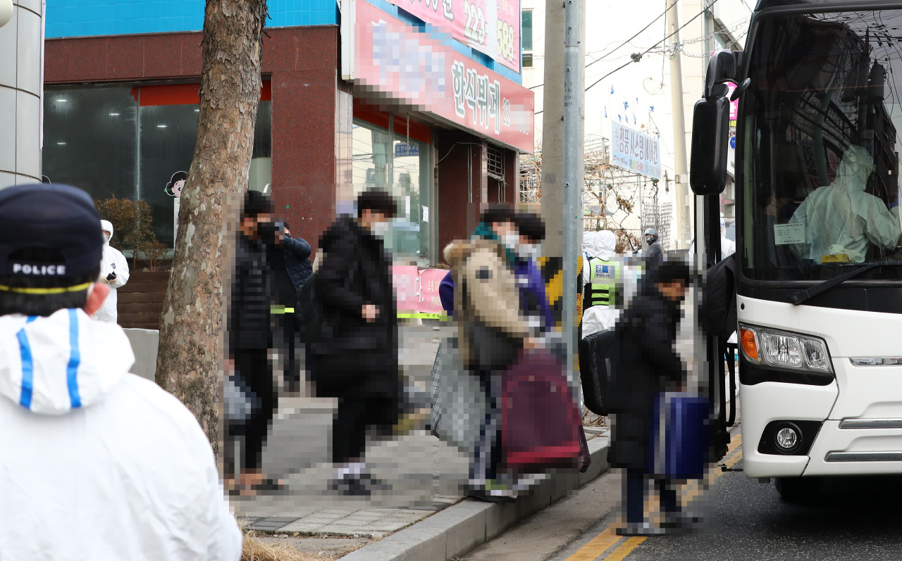 Students at IEM School in Daejeon, 164 kilometers south of Seoul, who contracted COVID-19 board a bus to be transported to a treatment facility in a nearby city, on Monday. The unauthorized boarding school facility has been hit by a mass virus outbreak that has infected 127 patients. (Yonhap)