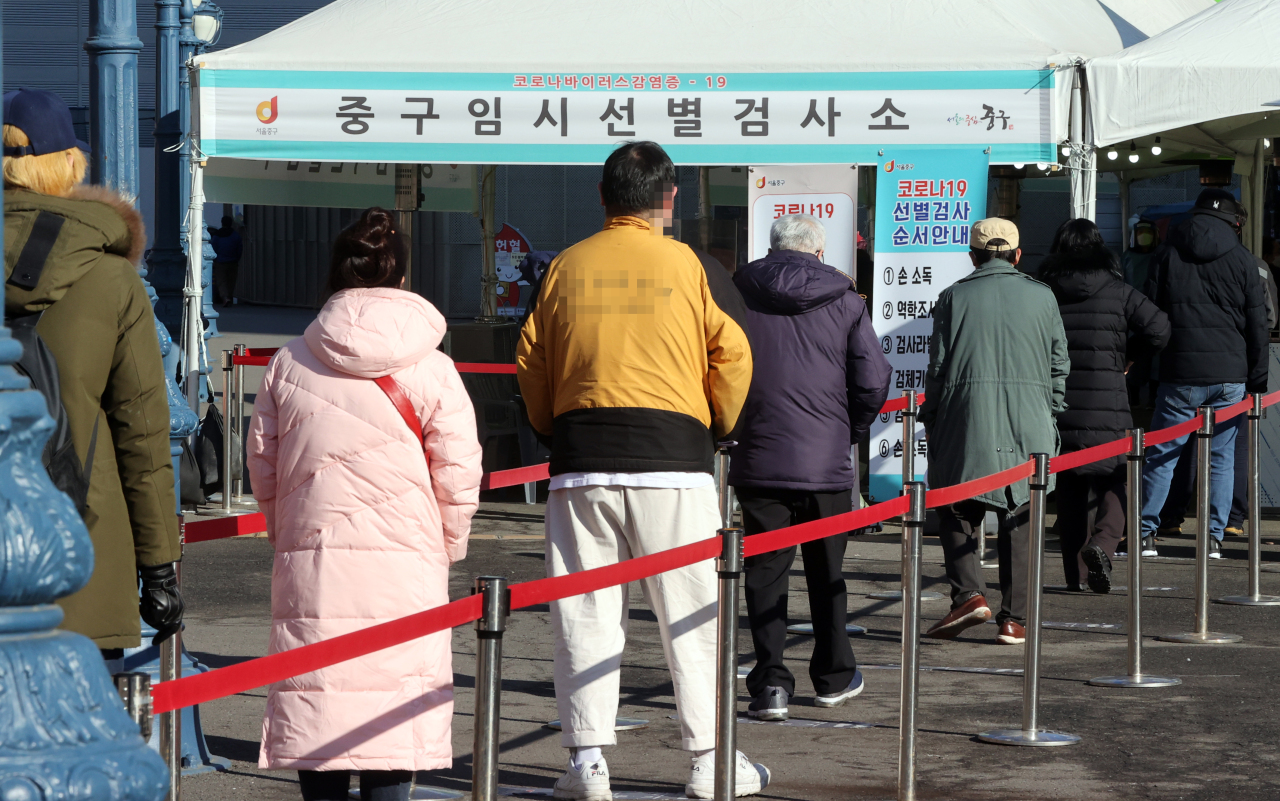 People wait in line Tuesday at a diagnostic center made near the Seoul Station in Jung-gu, central Seoul. (Yonhap)