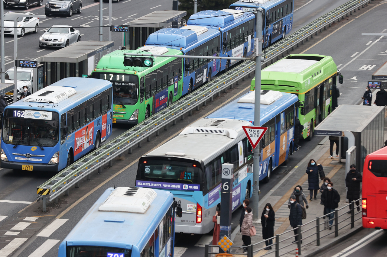 People wait to board buses at a bus terminal near the Seoul Station on Wednesdasy. Public transit operators are facing serious financial risks as the number of users sharply dropped last year from the impact of COVID-19 pandemic. (Yonhap)