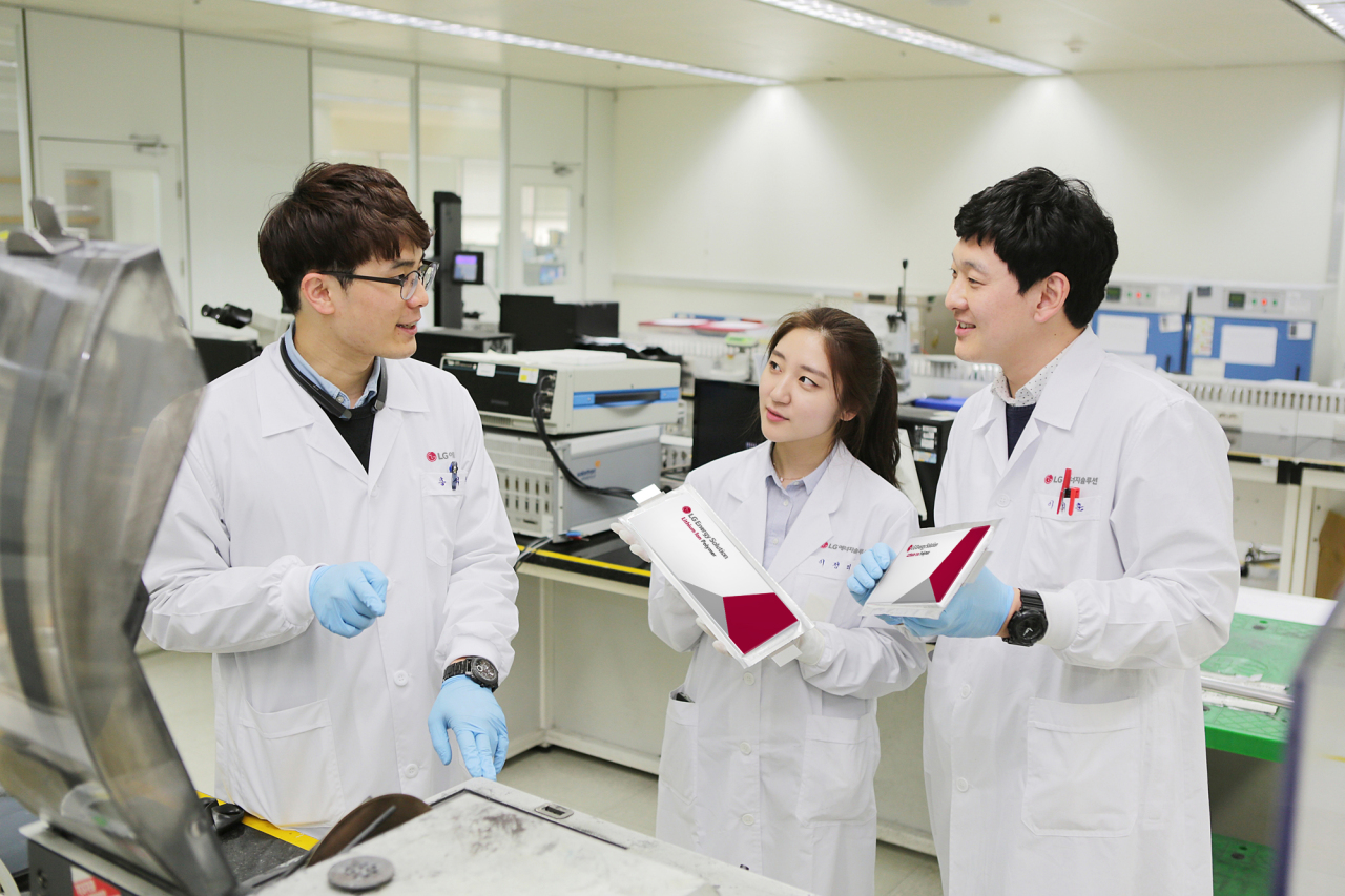 LG Energy Solution officials hold pouch-type batteries at the company’s research facility in Daejeon. (LG Energy Solution)