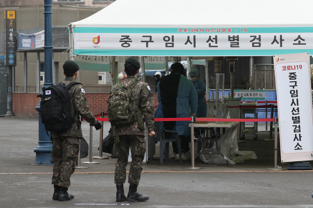 This photo, taken on Tuesday, shows service members at a temporary virus test center at Seoul Station in the capital. (Yonhap)