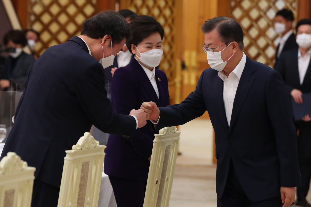 President Moon Jae-in (R) bumps fists with ruling Democratic Party leader Lee Nak-yon during a meeting at Cheong Wa Dae in Seoul on Friday. (Yonhap)