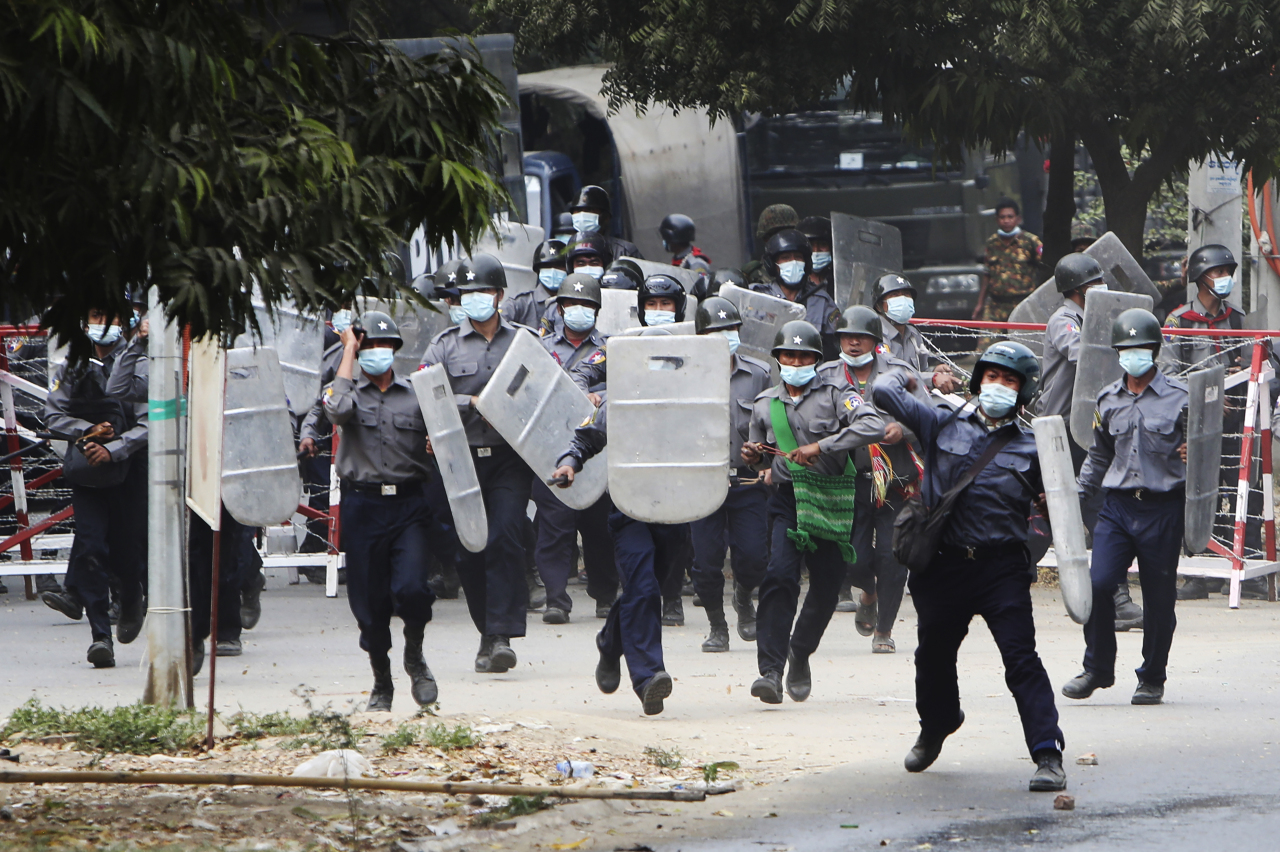Police charge forward to disperse protesters in Mandalay, Myanmar on Saturday. Security forces in Myanmar ratcheted up their pressure against anti-coup protesters Saturday, using water cannons, tear gas, slingshots and rubber bullets against demonstrators and striking dock workers in Mandalay, the nation's second-largest city. (AP-Yonhap)