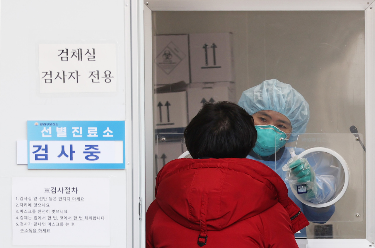A medical worker carries out COVID-19 tests at a makeshift clinic in Seoul on Sunday. (Yonhap)